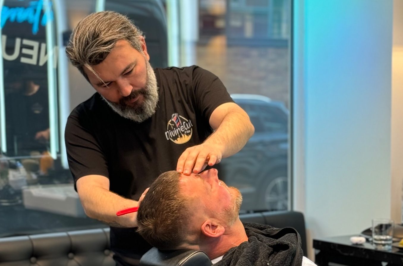 Barbier bei der Nassrasur im Barbershop Frankfurt Friseur vollzieht eine Nassrasur eines Mannes in einem modernen Friseuralon.