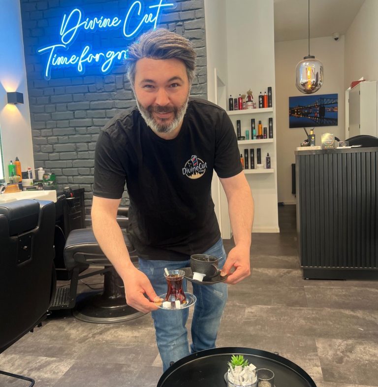 Friseur serviert Tee und Kaffee in einem modernen Barbershop Frankfurt